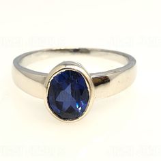 a close up of a ring with a blue stone in the center on a white background