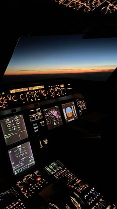 the view from inside an airplane cockpit at night with illuminated instruments and lights on it