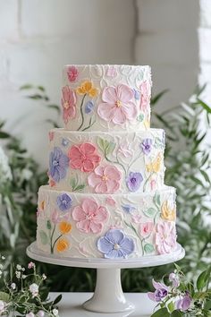 a multi - tiered cake with flowers painted on it