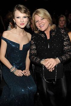 two women sitting next to each other at a formal event