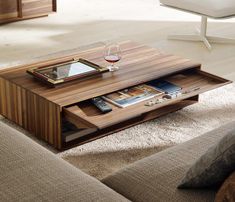 a coffee table with a tablet on it in the middle of a living room area