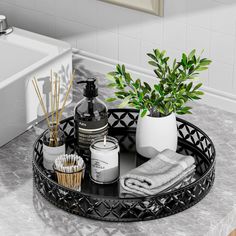 a black tray with candles, soaps and other items on it in a bathroom