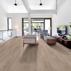 a living room filled with furniture and a flat screen tv on top of a hard wood floor