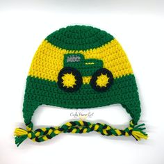 a crocheted green and yellow hat with a tractor on the front is shown