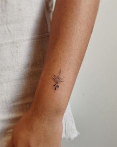 a woman's arm with a small tattoo on the left side of her wrist