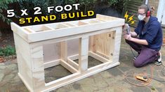 a man kneeling down next to a wooden table with the words 5x2 foot stand build