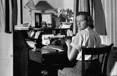 an old photo of a woman sitting at a desk