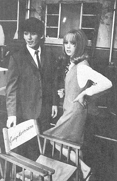 an old black and white photo of two people standing next to chairs