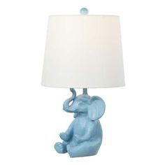 an elephant lamp sitting on top of a table next to a white lampshade