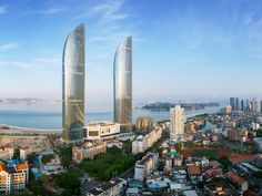 an aerial view of two skyscrapers next to the ocean