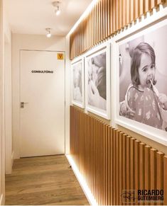 a hallway with three pictures on the wall and a wooden slatted wall behind it