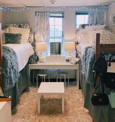 two beds in a room with lights on the ceiling and carpeted floor, one is white