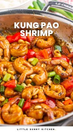 a pan filled with shrimp and vegetables on top of a stove next to green beans