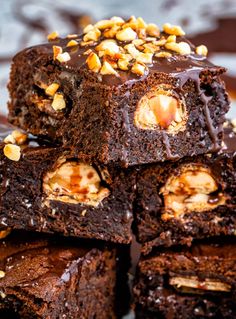 chocolate brownies stacked on top of each other with nuts in the middle and one cut in half