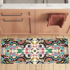 a bathroom rug with an ornate design on the floor next to a sink and cabinets