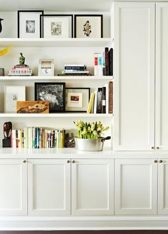 a white bookcase filled with lots of books