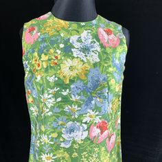 "Wonderful vintage Margaret Smith shift dress from the 1970's when her clothes were in Bonwit Teller and speciality shops across the country. Daisies, tulips and other colorful flowers on a green background. Soft easy care cotton blend fabric. Size 10 Bust: 35-36\" Waist: 34\" Hips: 34-35\" Length: 40.5\" Excellent condition no issues. There is an 1.5\" wide separate belt of the same fabric with this dress. This will be your go to dress for hot weather and resort vacations. Sale supports Vermont Sleeveless Retro Print Dress For Garden Party, Sleeveless Dress With Retro Print For Garden Party, 1970s Sleeveless Floral Print Dress, 1970s Style Sleeveless Floral Print Dress, Mid-century Floral Print Dress For Spring, Mid-century Floral Print Spring Dress, Sun Dress, Floral Sleeveless, Green Background