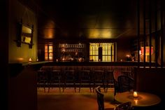 a dimly lit bar with chairs and candles