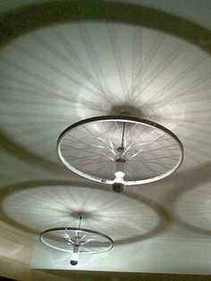 there are three bicycles that are hanging from the ceiling in this room, and one is spinning upside down