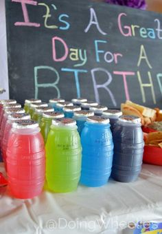 there is a birthday party with drinks on the table and chalkboard in the background