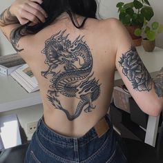 a woman with dragon tattoos on her back