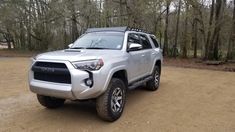 a silver toyota 4runner is parked in the dirt