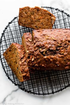 sliced loaf of banana bread on a wire rack with two slices cut off the side