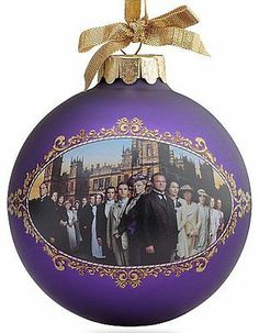 a christmas ornament with an image of the cast of downton abbey on it