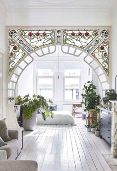 a living room filled with furniture and a fire place in front of a stained glass window