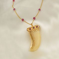 The belief and the motif of the 'claw' both transcend time and geography, and have seen multiple adaptations tying in with mystic beliefs. Drawing on this storied motif, here's our adaptation of it in this pendant worked on yellow quartz, detailed with gold and rubies. The pendant is strung on a gold chain interspersed Yellow Quartz, Heirlooms Jewelry, Unique Jewelry Designs, Amulets, Evil Eye Bracelet, Adaptation, Jewelry Branding, Vintage Charms, Geography