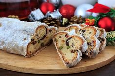 a wooden plate topped with sliced cake next to christmas decorations