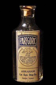 an old fashioned bottle is sitting on the table in front of a black background with gold trimmings