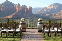 an outdoor ceremony set up with chairs and flowers on the aisle in front of mountains