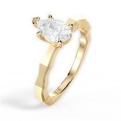 a yellow gold engagement ring with a pear shaped diamond in the center, on a white background