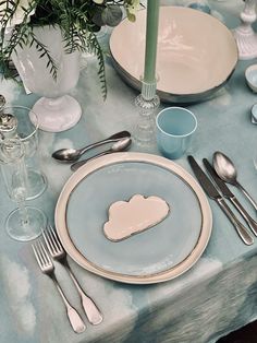 a table set with plates, silverware and flowers