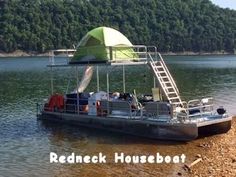 a houseboat is parked on the shore with a tent in the background