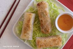 some food on a white plate with chopsticks and sauce in the bowl next to it