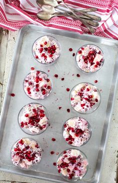 cupcakes with white frosting and pomegranate on a baking sheet