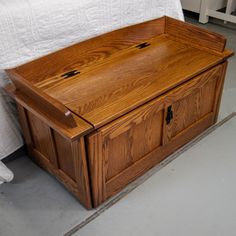 a wooden box sitting on the floor next to a bed