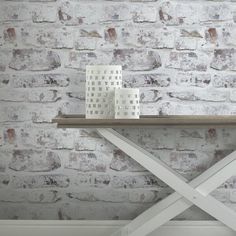 two white vases sitting on top of a wooden table in front of a brick wall