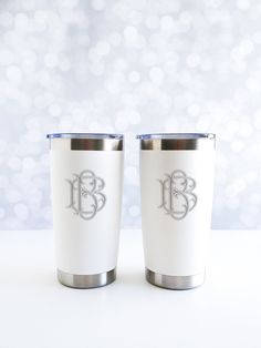 two white tumblers with the initials b and c on them sitting next to each other