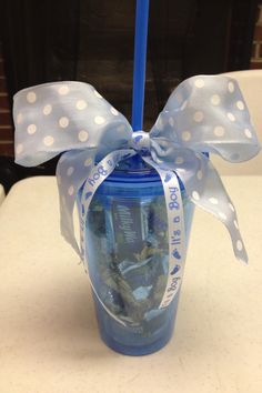 a blue cup with white polka dots on it and a ribbon tied around the top