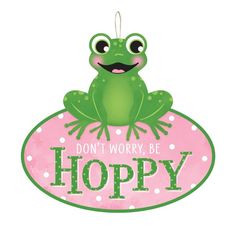 a green frog sitting on top of a pink sign that says don't worry, be hoppy