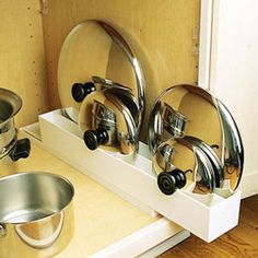 several pots and pans sitting on top of a white shelf next to a stove