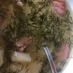 a bowl filled with meat and vegetables next to a spoon