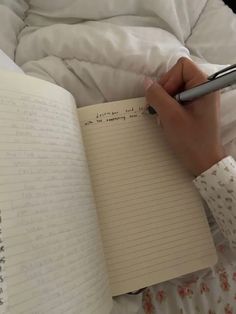 a person writing in a notebook with a pen