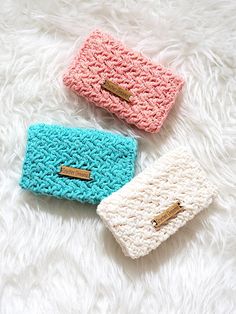 three crocheted purses sitting on top of a white furnishing floor