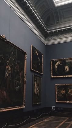 several paintings are hanging on the wall in a museum