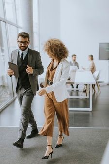 two business people walking in an office building