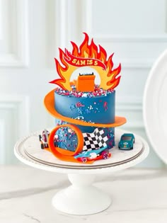 a three tiered cake with cars and flames on it